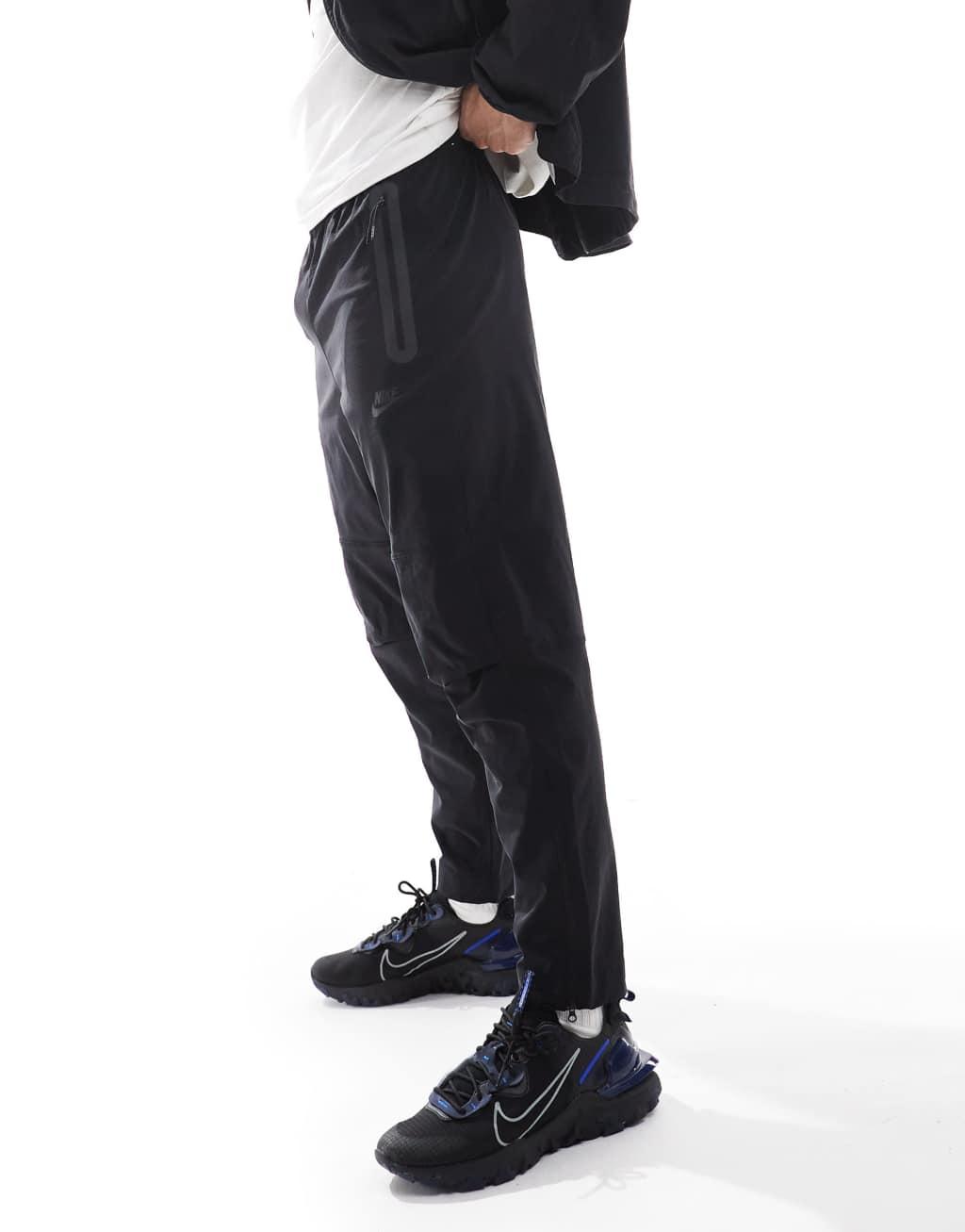 Nike Tech Woven tapered pants in black Product Image