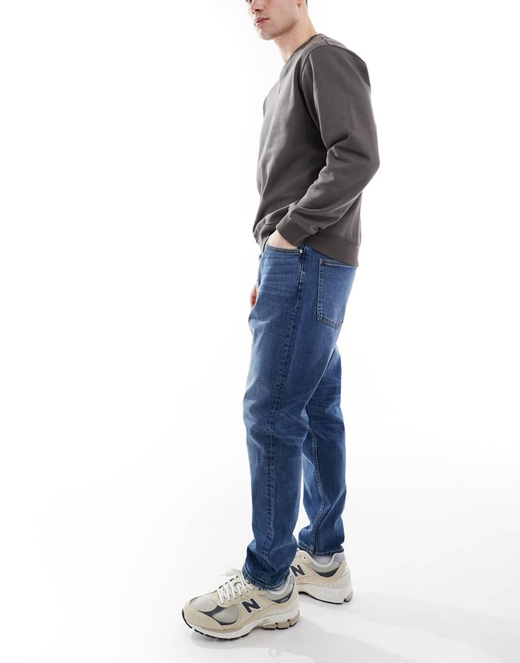 ASOS DESIGN stretch tapered jeans in mid wash Product Image