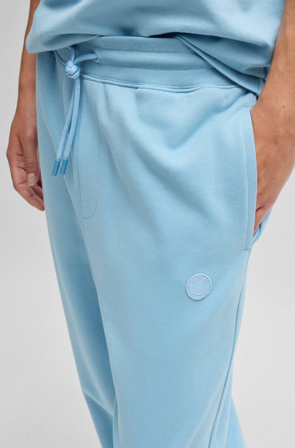 Cotton-terry tracksuit bottoms with Happy HUGO logo Product Image
