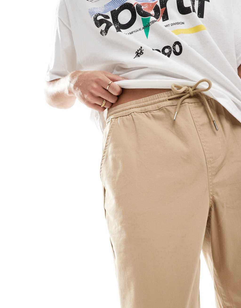 ASOS DESIGN tapered pull on chino with elastic waist in beige Product Image
