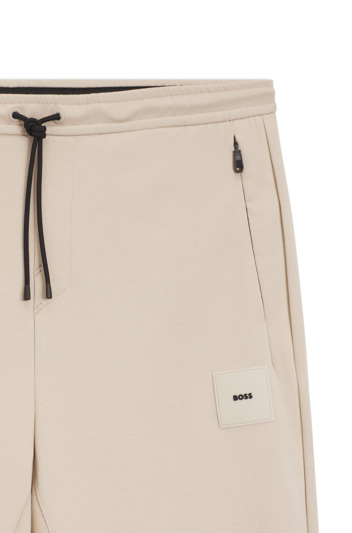 Stretch tracksuit bottoms with logo patch Product Image