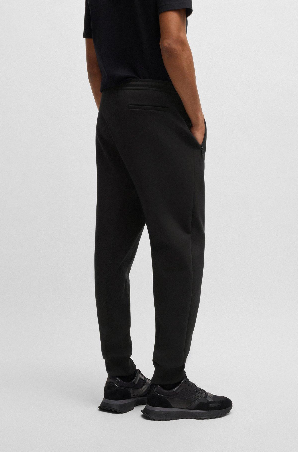 Stretch tracksuit bottoms with logo patch Product Image