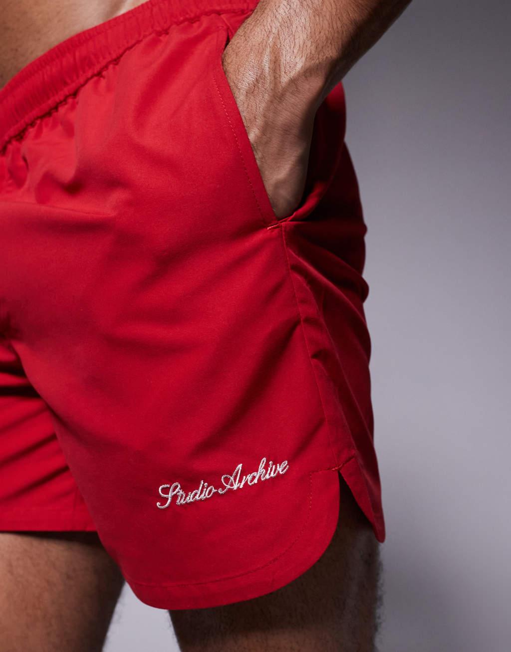 ASOS DESIGN swim shorts in mid length with embroidery in red Product Image