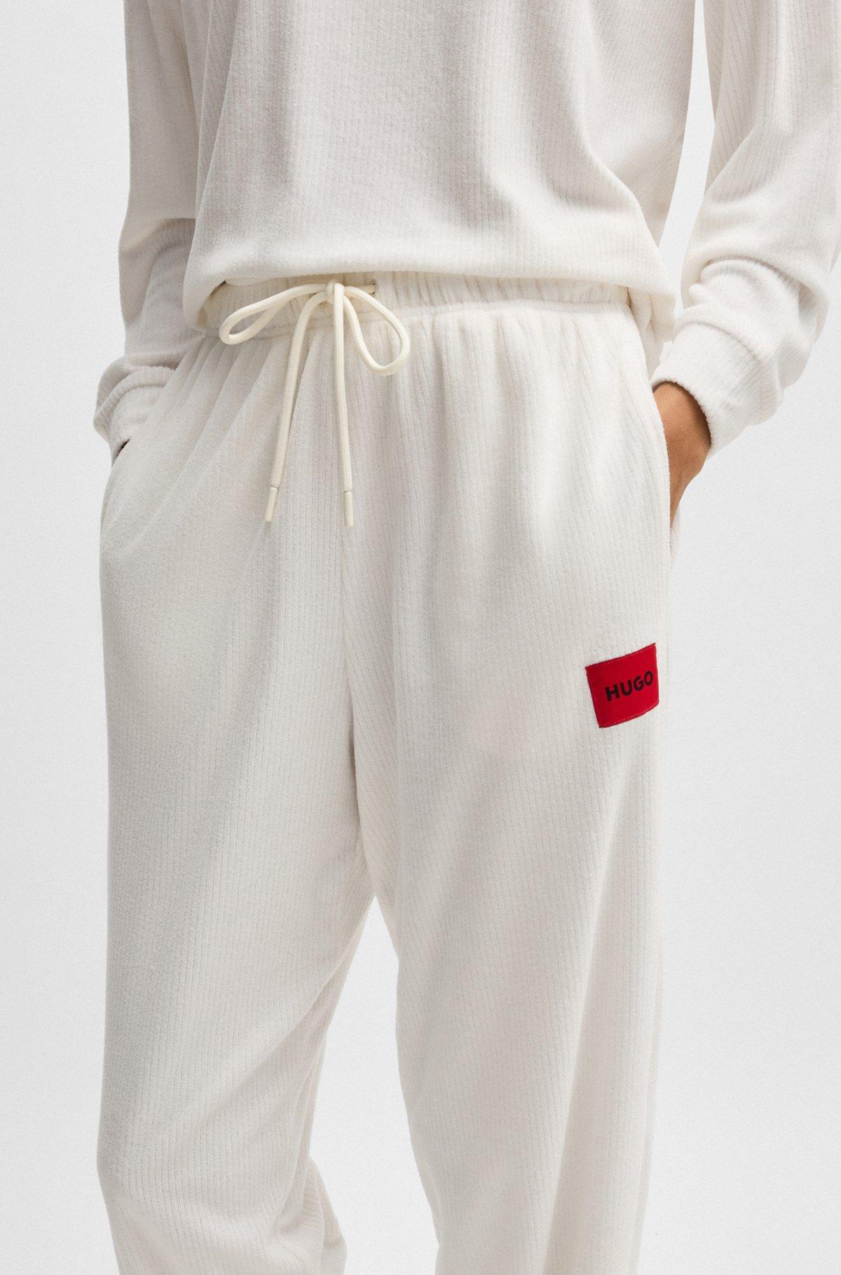 Tracksuit bottoms with red logo label Product Image