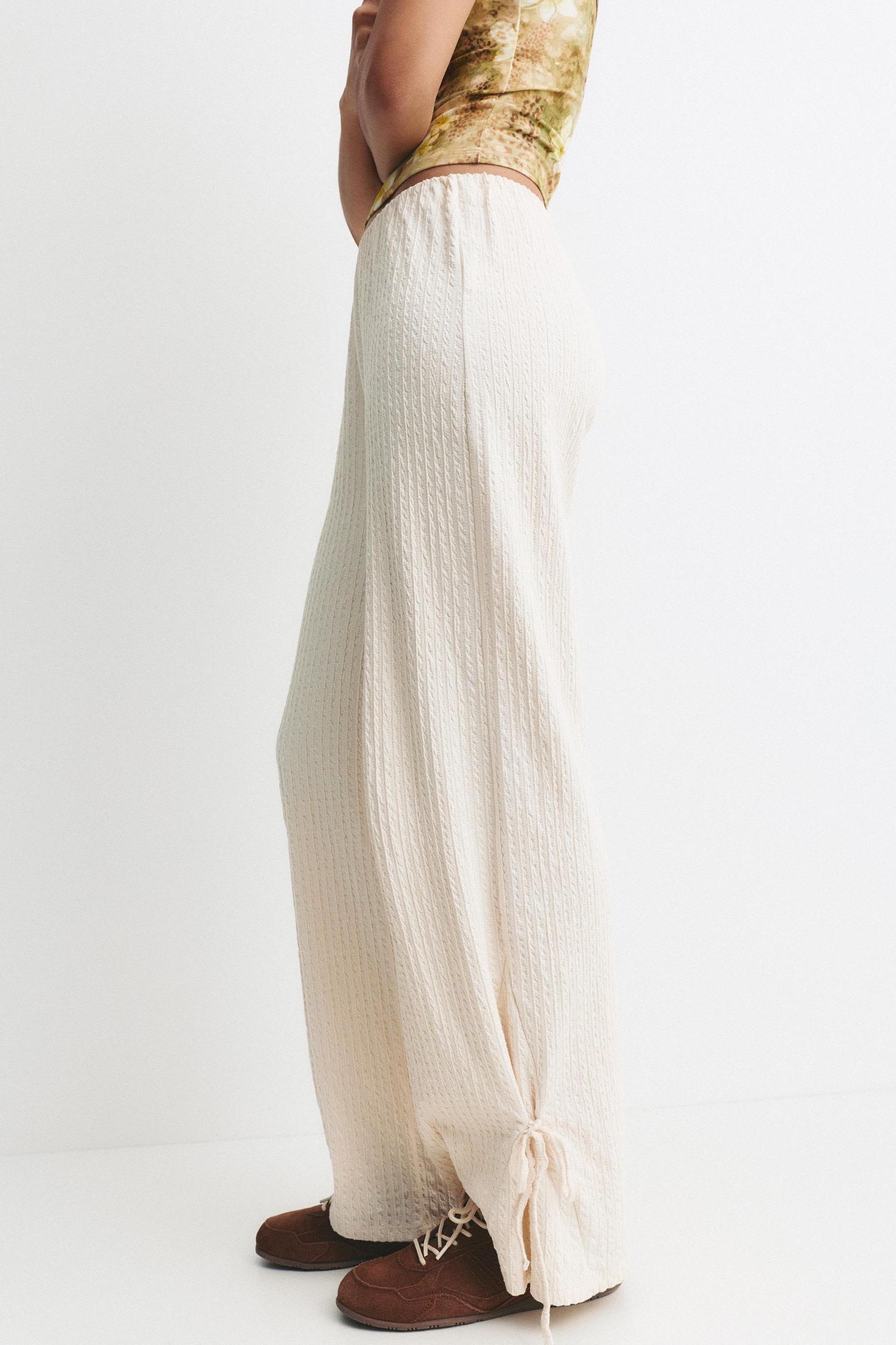 Rustic trousers with knot detail Product Image