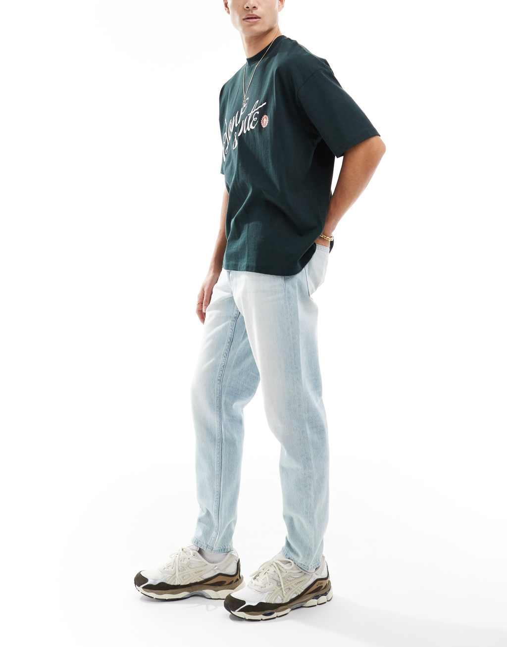 ASOS DESIGN tapered fit jeans in light wash blue Product Image