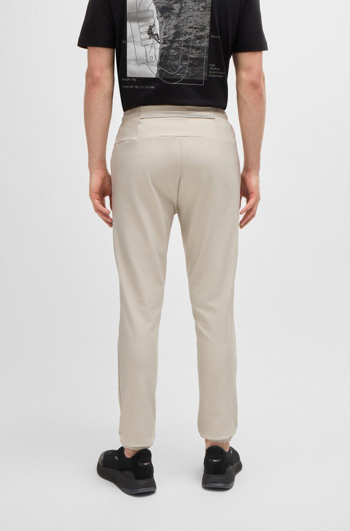 Tracksuit bottoms in stretch fabric with decorative reflective logo Product Image