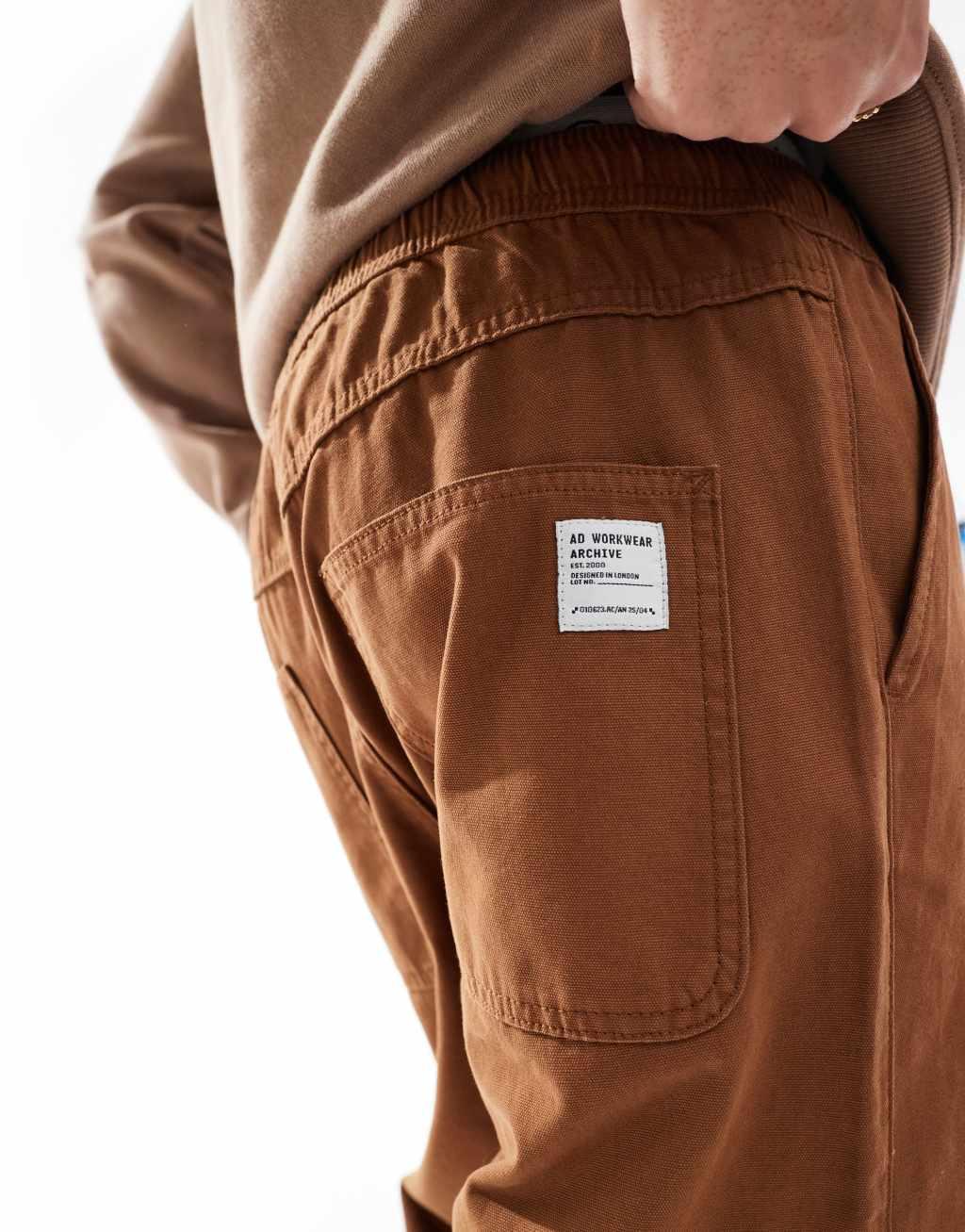 ASOS DESIGN baggy pull on pants with back pocket patch in brown Product Image