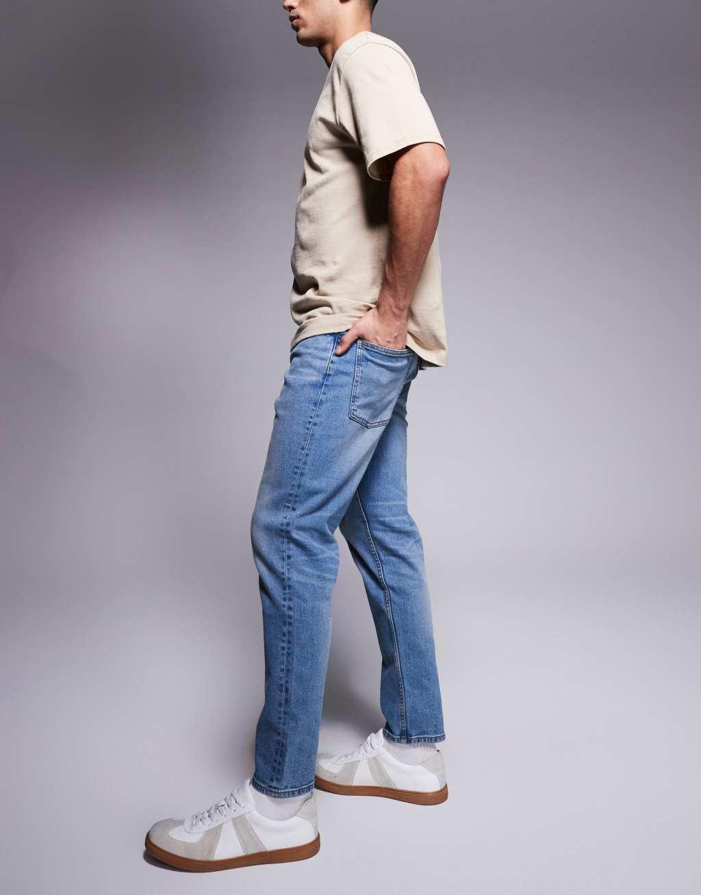 ASOS DSIGN stretch tapered jeans in mid wash with vintage tint Product Image
