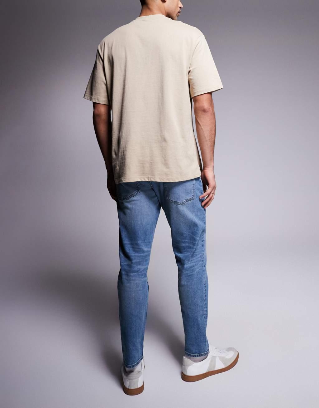 ASOS DSIGN stretch tapered jeans in mid wash with vintage tint Product Image